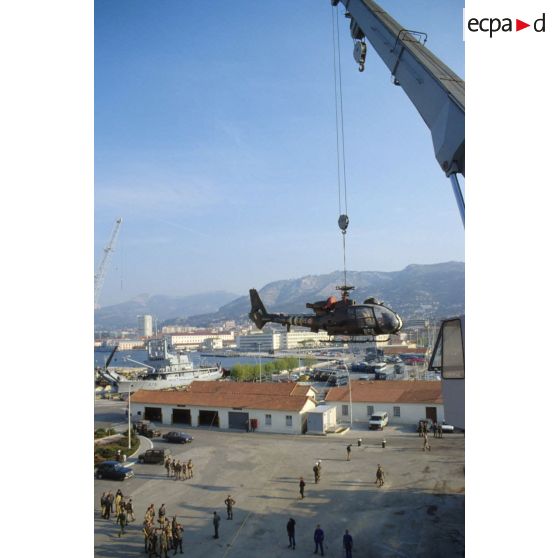 Un hélicoptère de combat Gazelle du 3e RHC (régiment d'hélicoptères de combat) es treuillé par une grue du TCD (transport de chalands de débarquement) Foudre vers le quai du port de Toulon.