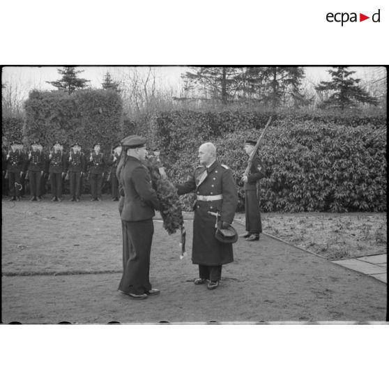 L'amiral Hermann Densch dépose une couronne au pied d'un monument en forme de croix.