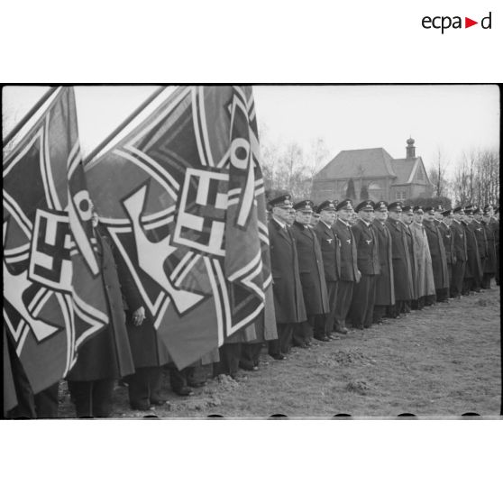 Dans un cimetière, lors d'une cérémonie d'hommage, les anciens combattants allemands et leurs drapeaux.