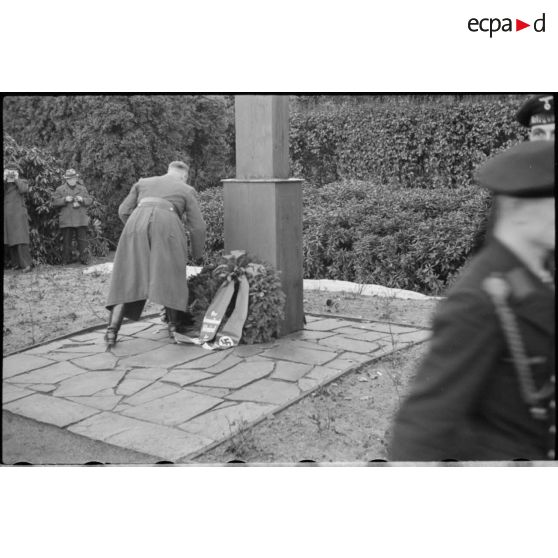 Lors d'une cérémonie d'hommage, des cadres du NSDAP déposent des couronnes mortuaires au pied d'une croix.