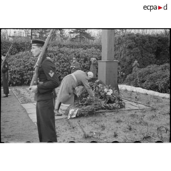 Lors d'une cérémonie d'hommage, des cadres du NSDAP déposent des couronnes mortuaires au pied d'une croix.