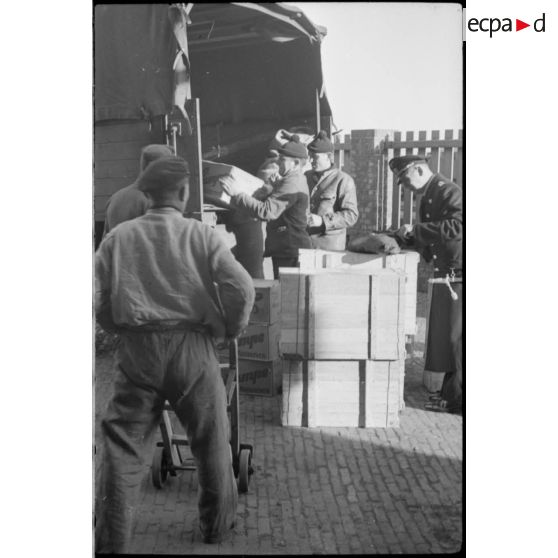 Chargement dans des camions de denrées pour les marins d'un bâtiment de surface.