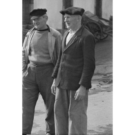 Deux hommes dont un vieillard observent le retour de la pêche dans le port de Douarnenez.