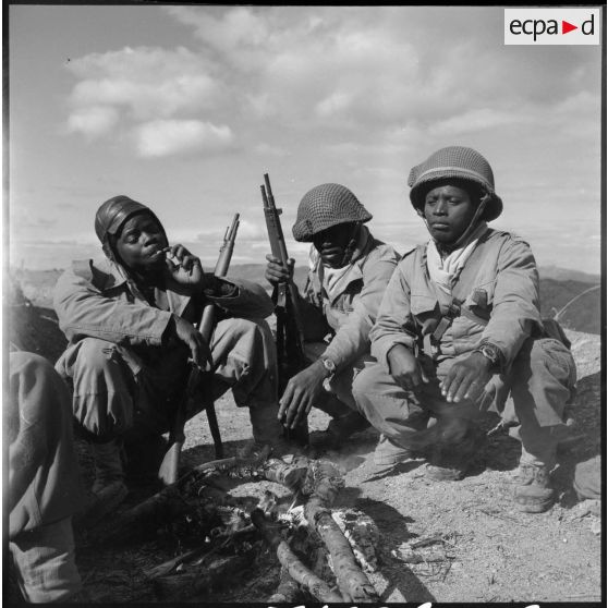 Des tirailleurs de la 6e compagnie du 2/IIe RIC se réchauffent.