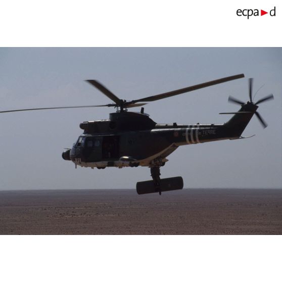 Un hélicoptère de transport Puma Orchidée (observatoire radar cohérent héliporté d'investigation des éléments ennemis) survole le désert saoudien.