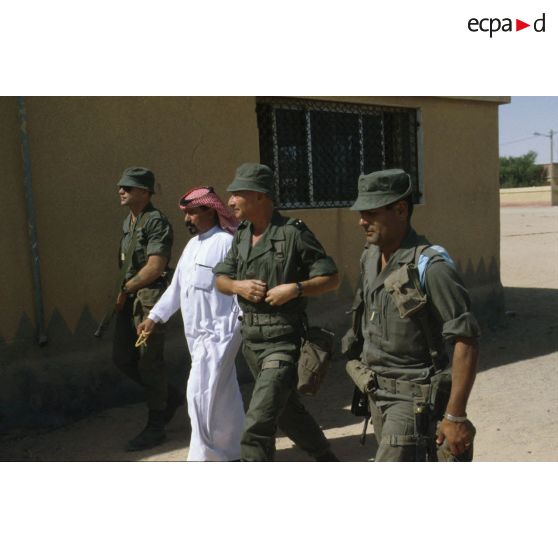 Le général de brigade Jean-Charles Mouscardès, commandant la division Daguet, visite un village en compagnie du maire.