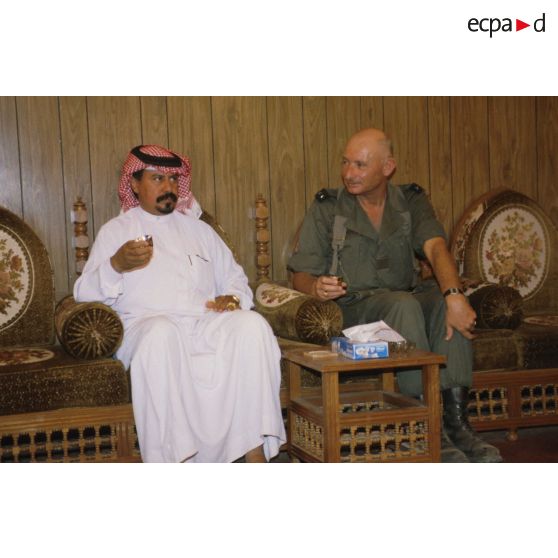 Le général de brigade Jean-Charles Mouscardès, commandant la division Daguet, s'entretient avec le maire du village autour d'un thé.