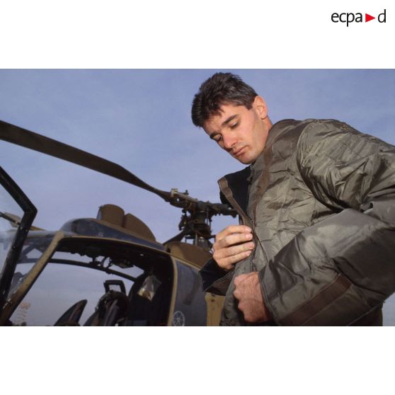 Un membre de l'équipage d'un d'hélicoptère de combat Gazelle Hot du 5e RHC revêt la tenue S-3P (survêtement de protection à port permanent) lors d'un exercice NBC.