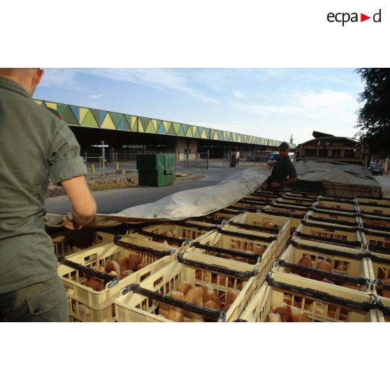 Le pain fabriqué par la boulangerie est chargé par les hommes du 511e RT sur des camions pour être livré aux troupes stationnées à Hafar al Batin. Les camions ainsi chargés sont bâchés.