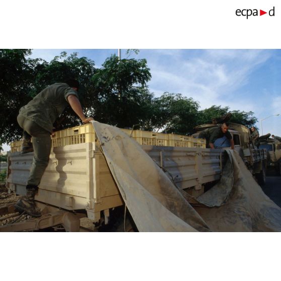 Le pain fabriqué par la boulangerie est chargé par les hommes du 511e RT sur des camions pour être livré aux troupes stationnées à Hafar al Batin. Les camions ainsi chargés sont bâchés.
