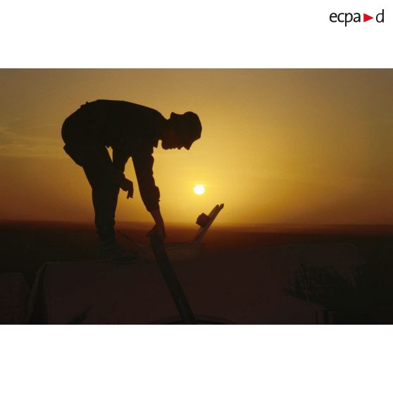 Coucher de soleil sur la station d'épuration et de distribution de l'eau tenue par les éléments du 17e RGP. L'un d'eux remplit une citerne.