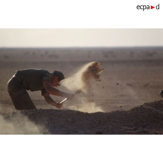 Installation du bivouac du 1er RI pour la nuit, un militaire creuse un trou de combat.