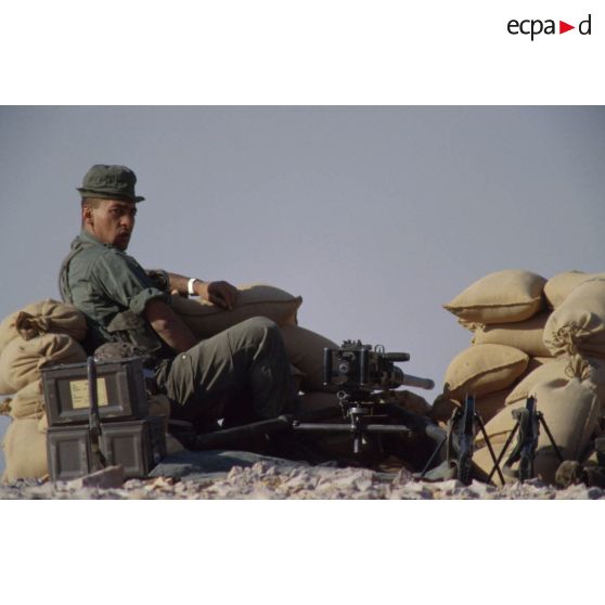 Poste de combat et d'observation au bivouac du 1er RI. Un soldat est posté derrière des sacs de sable avec une mitrailleuse Browning 12,7 mm.