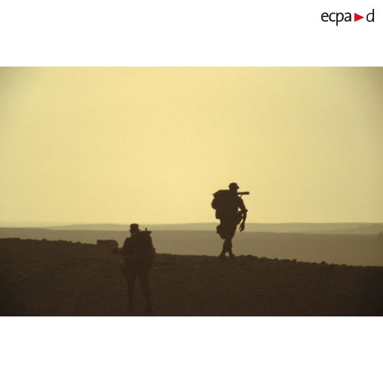 Deux militaires d'un groupe de combat du 1er RI marchent pour rejoindre un lieu d'héliportage par les appareils du 1er RHC (régiment d'hélicoptères de combat).