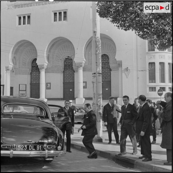 Lors de sa visite à Alger Robert Lacoste, ministre de l'Algérie, monte dans le véhicule officiel (Delahaye) stationné devant le bâtiment de la Poste.