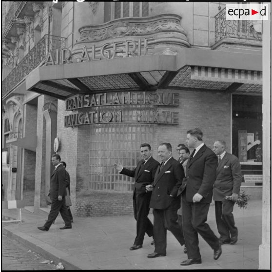 Robert Lacoste, ministre de l'Algérie, et sa délégation dans les rues d'Alger, devant le bâtiment Air Algérie.