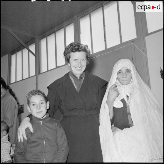 Madame Massu avec un élève et sa mère à l’occasion d’une distribution de vêtements.