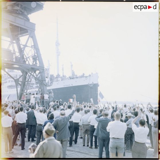 La foule fait ses adieux aux militaires embarqués sur l'Athos II, qui quitte le port d'Alger.