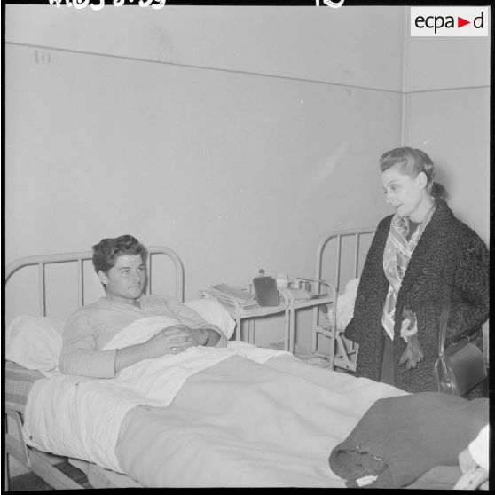 Madame Salan rend visite aux malades hospitalisés.