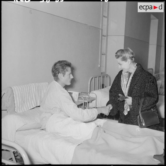 Madame Salan rend visite aux malades hospitalisés.