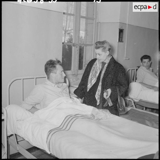Madame Salan rend visite aux malades hospitalisés.