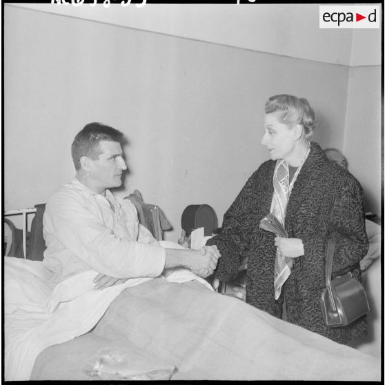 Madame Salan rend visite aux malades hospitalisés.