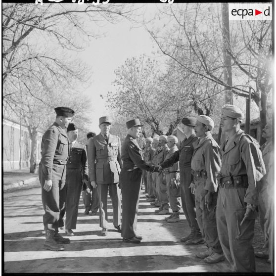 Le général d'armée Salan salue des soldats.