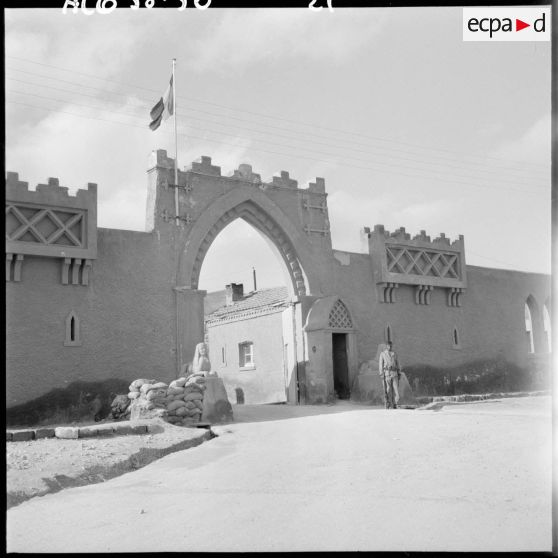 Entrée de la ville de Méchéria. La porte est surmontée du drapeau tricolore.