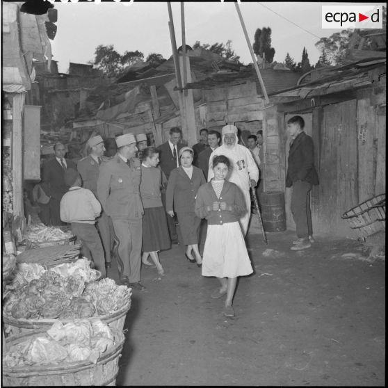 Mesdames Lacoste et Baret, épouses du ministre de l'Algérie et du préfet d'Alger, visitent la cité Mahieddine d’Alger.
