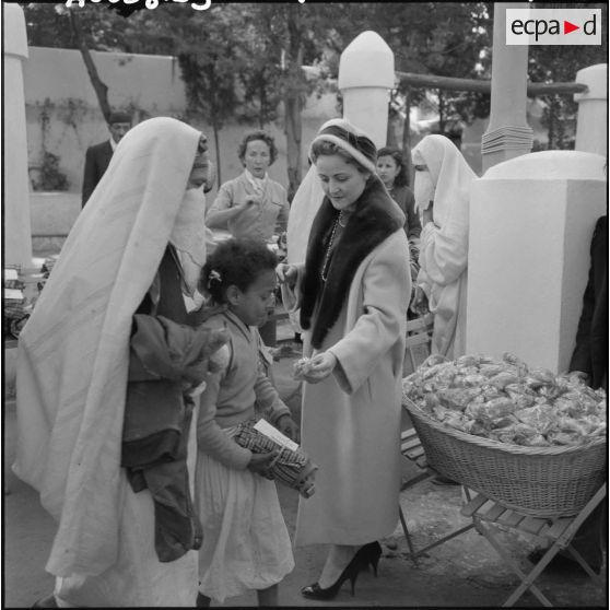 Madame Baret offre des friandises aux enfants lors de sa visite à la cité Mahieddine d’Alger.