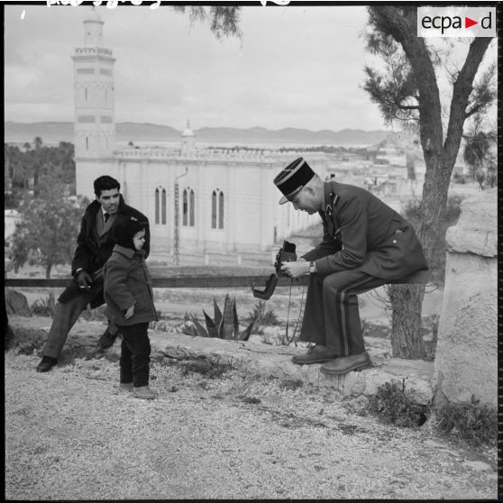 Un officier supérieur prend un enfant en photo.