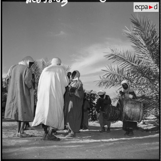 Hommes en tenue traditionnelle avec des enfants jouant du tambour.