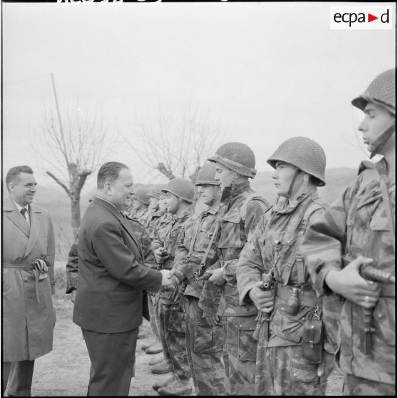 Robert Lacoste, ministre de l’Algérie, visite les parachutistes du 9e régiment de chasseurs parachutistes (9e RCP) lors de sa visite dans l’est constantinois.
