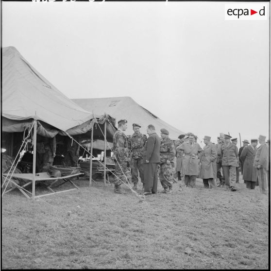 Robert Lacoste, ministre de l’Algérie, visite le cantonnement du 9e régiment de chasseurs parachutistes (9e RCP) lors de sa visite dans l’est constantinois.
