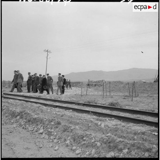Pierre Métayer, secrétaire d’État aux forces de l'armée de terre, avec un groupe d’officiers sur une voie ferrée.