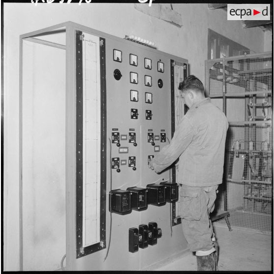 Un homme devant une armoire électrique.