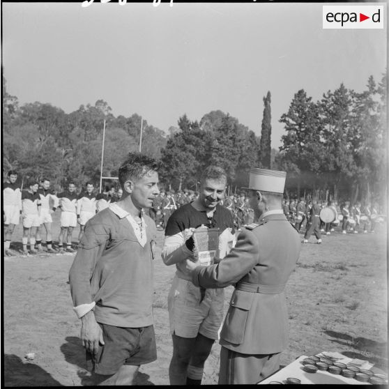 Un officier remet le fanion du champion inter-armées de rugby d'Afrique du Nord lors d'une compétition.
