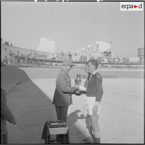 Un officier remet une coupe au champion inter-armées d'Afrique du Nord de football.