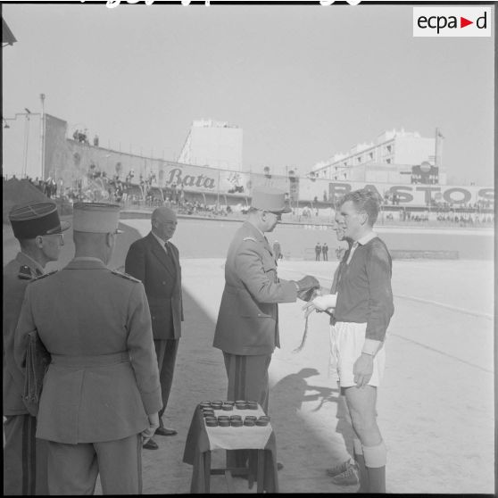 Un officier remet un fanion au champion inter-armées d'Afrique du Nord de football.