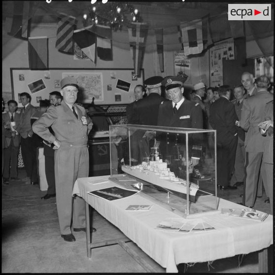 Le général d'armée Salan et l'amiral Auboyneau devant une maquette de bateau lors d'une exposition de la Marine à Alger.