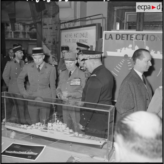 Le général d'armée Salan devant une maquette de bateau lors d'une xposition de la Marine à Alger.