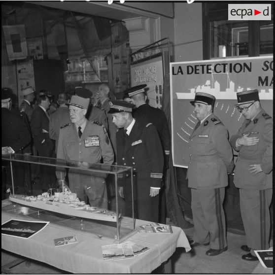 Le général d'armée Salan et l'amiral Auboyneau devant une maquette de bateau lors d'une exposition de la Marine à Alger.