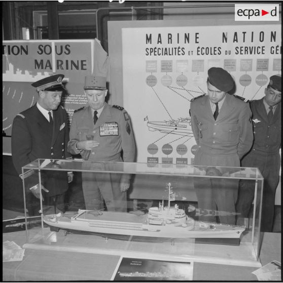 Le général d'armée Salan et l'amiral Auboyneau devant une maquette de bateau lors d'une exposition de la Marine à Alger.