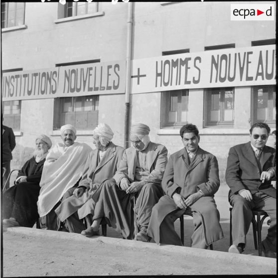Un groupe d’Algériens assis sur un banc.