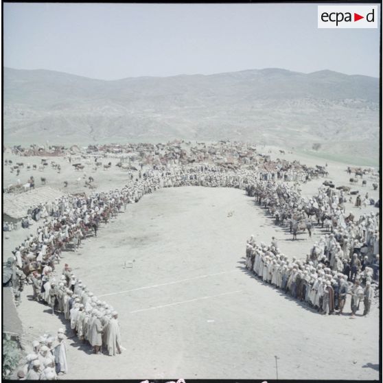 Population d'un douar réunie autour d'une harka à cheval.