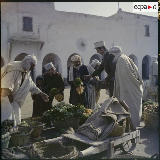 Deux légionnaires achètent des légumes sur un marché.