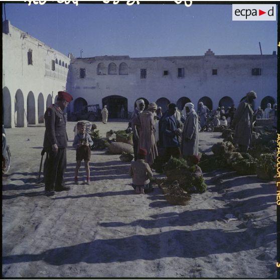 Un officier et son fils sur un marché.