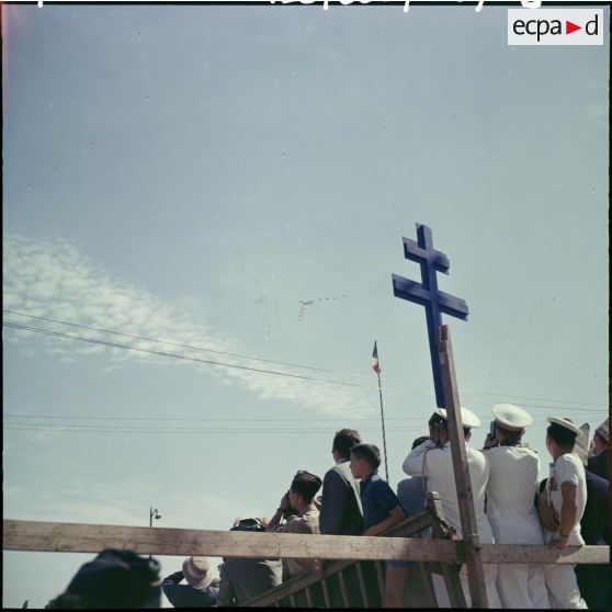 La foule observe une patrouille aérienne au pied de la croix de Lorraine, lors de la venue du général de Gaulle à Constantine.