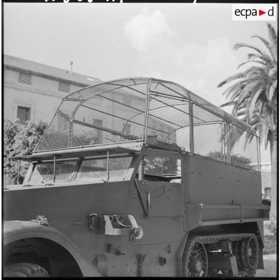 Half-track devant un bâtiment.