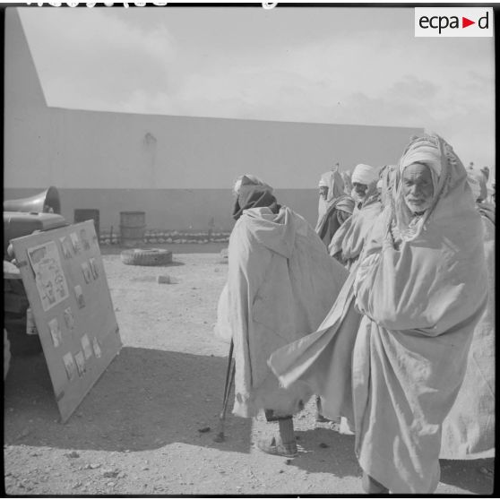 La foule regardant un panneau d'information pendant une séance de Public-Adress.